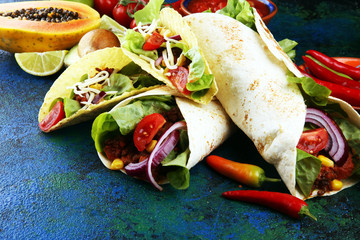Mexican food, including tacos, guacamole, nachos and pepper on rustic table