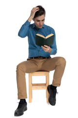smart casual man holding hand to head and reading