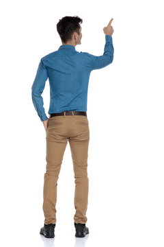 back view of smart casual man in blue shirt pointing finger