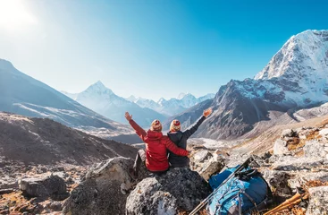 Photo sur Plexiglas Ama Dablam Couple levant les bras se réjouissant de la route de trekking du camp de base de l& 39 Everest près de Dughla 4620m. Les routards ont laissé des sacs à dos et des bâtons de randonnée et profitant de la vue sur la vallée avec le pic Ama Dablam 6812m et le 