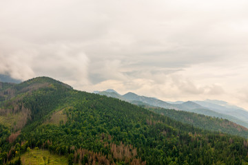 Fototapeta na wymiar Tatry mountains covered with beautiful forests and covered with thick fog and clouds
