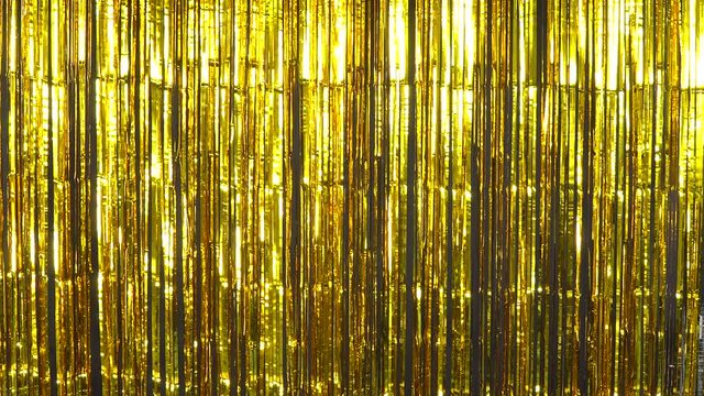 Shimmering golden foil tinsel fringe background for stage, New Years, birthday, wedding, or any celebration, pary or event