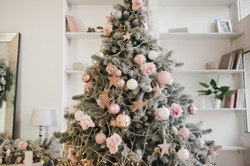 Christmas tree with toys in pastel colors. Pink, white, gold color. Place for text.