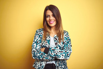 Young beautiful woman wearing casual jacket over yellow isolated background happy face smiling with crossed arms looking at the camera. Positive person.