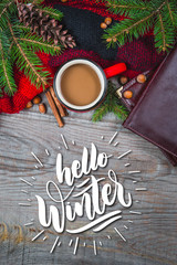 Hot coffee cup with cozy blanket on a wooden table with decorations