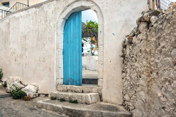 Fototapeta na wymiar Opened door in old abandoned wall, Crete island, Greece