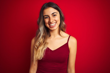 Young beautiful woman wearing a t-shirt over red isolated background with a happy and cool smile on face. Lucky person.