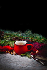 Hot coffee cup with cozy blanket on a wooden table with decorations