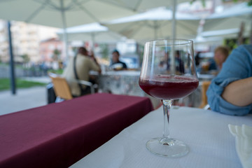 Glass of red sangria in wine glass on table at outdoor restaurant