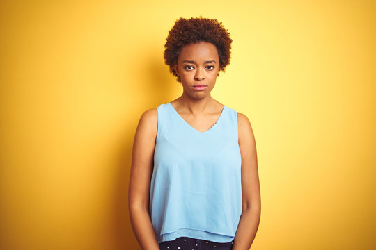 Beautiful african american woman wearing elegant shirt over isolated yellow background depressed and worry for distress, crying angry and afraid. Sad expression.