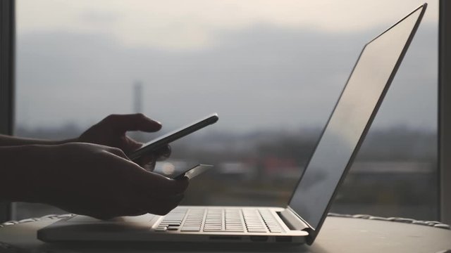 Female hands with credit debit card and cellphone shopping online entering digits and cvv code with laptop computer. Online shopping concept.