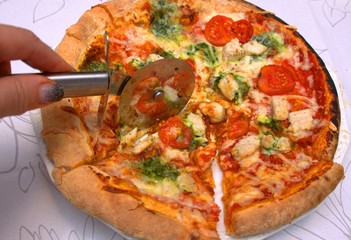 baked round pizza with sliced chicken and broccoli