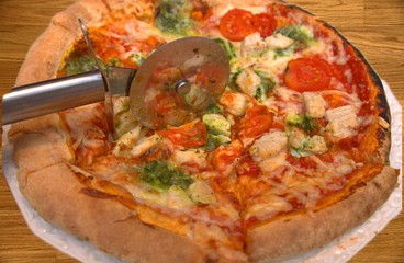 baked round pizza with sliced chicken and broccoli