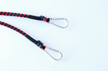Obraz premium The ends of a rubber cord to secure luggage with metal carabiners on a white background.