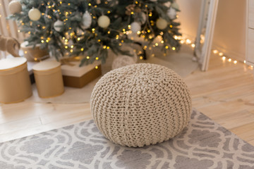 beige Ottoman under the Christmas tree. the interior of the bedroom.