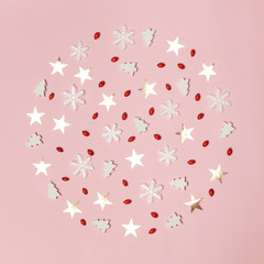 Elegant winter background. Red berries, snow flakes, stars and little christmas trees on pale pink background. Christmas, winter holiday, new year concept.	