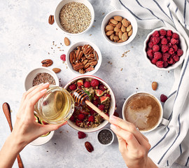 Healthy breakfast, top view. Oatmeal porridge with raspberries, figs, chia seeds, flax seeds, almonds and pecans, honey and coffee.