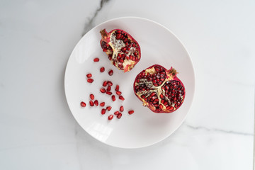The cut pomegranate lies on a white background. Close-up of the center of a pomegranate. An...