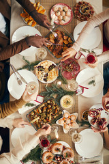 Above view background of people dining at festive Christmas table with delicious homemade food, copy space