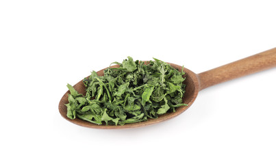 Wooden spoon with dried parsley on white background