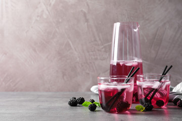 Delicious refreshing blackberry lemonade on grey table, Space for text