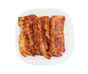 Slices of tasty fried bacon on white background, top view