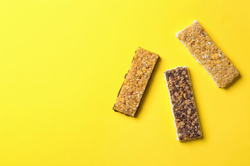 Healthy granola bars on yellow background, flat lay. Space for text