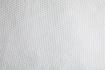 White knitted sweater as background, closeup view