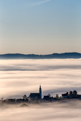 Frauenberg church and other surrounding houses emerging from thick fog - 300240480