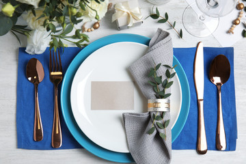 Elegant festive table setting on white wooden background, flat lay