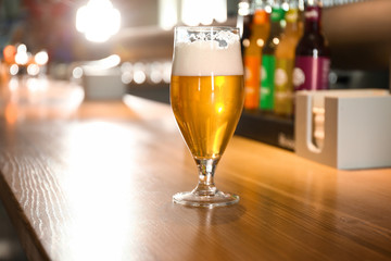 Glass of beer on wooden table in pub