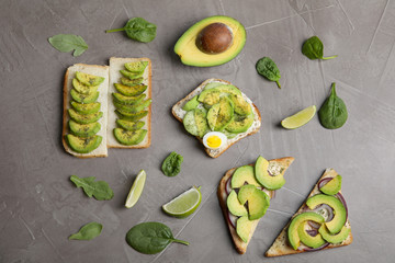 Flat lay composition with avocado toasts on grey table