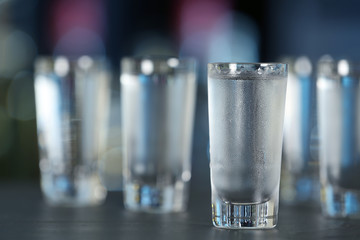 Shot of vodka on table against blurred background. Space for text