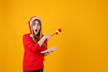 girl holding notebook writing notes and new year plans with pen isolated over yellow