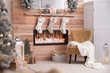 Fireplace with Christmas stockings in room. Festive interior