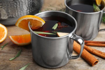 Tasty mulled wine with spices on wooden table