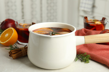 Tasty mulled wine with spices on light table in kitchen