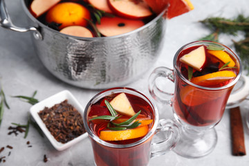 Tasty mulled wine with spices on grey marble table