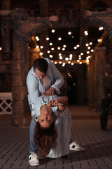 Beautiful young couple practicing dance moves in evening outdoors