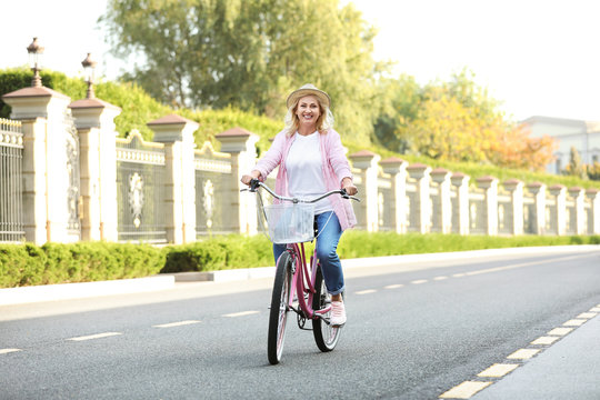 Mature woman riding bicycle outdoors. Active lifestyle