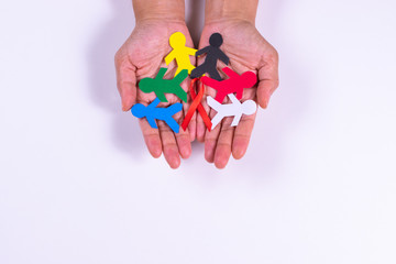 Red ribbon with people made from paper cut on her hands for world aids day.