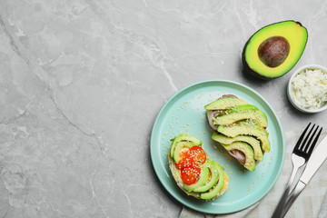 Flat lay composition with avocado sandwiches on light grey table. Space for text