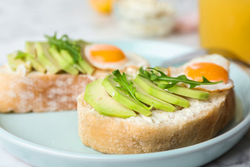 Plate of delicious avocado sandwiches on table, closeup