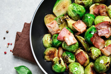 Delicious Brussels sprouts with bacon in pan on light table, closeup