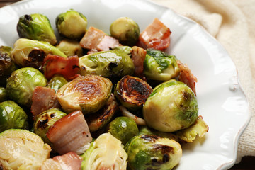Delicious Brussels sprouts with bacon in plate, closeup