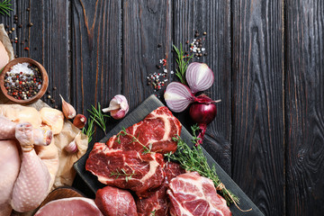 Flat lay composition with fresh meat on black wooden table