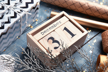 Wooden block calendar and festive decor on table, closeup