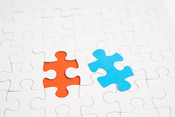Blue jigsaw piece and red hold jigsaw