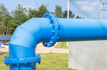 Fototapeta na wymiar Large blue main water supply steel pipe and flange connection pipeline with bolts and nuts connecting pipe fitting joint water supply system