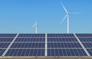 Solar panels and wind turbines generating electricity is solar energy and wind energy in hybrid power plant systems station